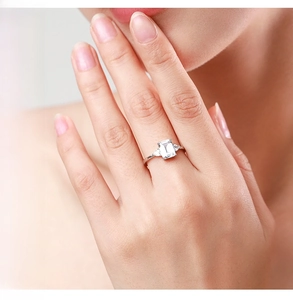 Macro detail of S925 silver ring featuring emerald cut zircon and side stones on finger