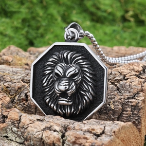 Macro detail of lion head pendant on tree bark highlighting silver stainless steel texture