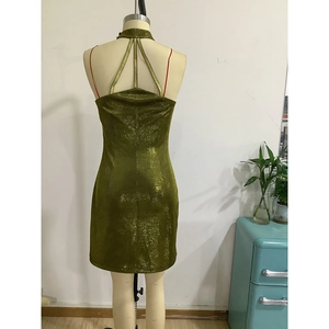 Detail of olive green metallic mini dress featuring cross back straps and shimmering fabric