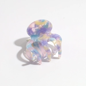 Macro shot of colorful marble pattern claw clip with octopus-style tentacles and glossy finish