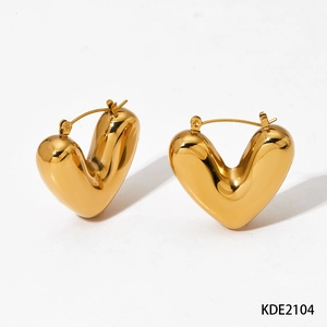 Macro detail of high-polish gold plated stainless steel 3D heart hoop earrings