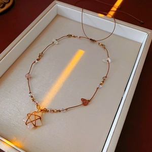 Détail du collier tissé à la main avec quartz rose en étoile et divers cristaux naturels
