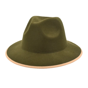 Detail view of green wool fedora hat with contrast pink brim binding and classic jazz crown