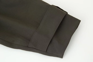 Gros plan détaillé sur la texture du tissu sergé olive foncé et les coutures de bord