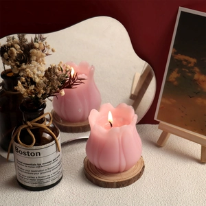 Candela a forma di tulipano rosa su base in legno con decori caldi e riflesso specchio