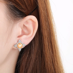 Macro shot of a high-quality 18K gold shell pearl earring with sparkling rhinestones