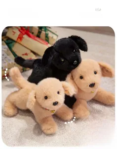 Gros plan de chiots en peluche dorés et noirs avec colliers rouges à clochettes chez soi