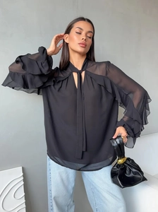 Detail of the tie-neck and ruffled chiffon sleeves on a stylish black elegant blouse