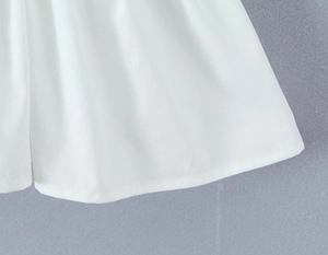 Gros plan détaillé sur la texture du tissu tissé blanc et l'ourlet à volants brodé