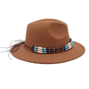 Detailed view of ethnic beaded band with blue beads and tassels on brown wool fedora hat