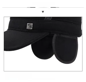 Detail of wool fabric texture and metal fashion emblem on black ear flap winter cap