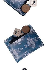 Detailed view of skull pattern wallet with coins and keys showing compact size and texture