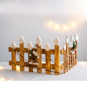 Close-up of wooden Christmas fence decoration with faux snow, pine cones and berries