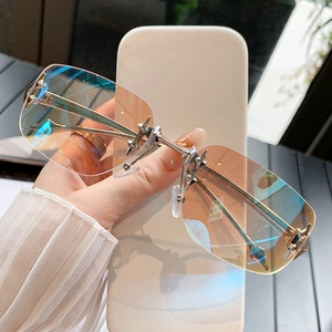Frameless star design sunglasses with orange-blue gradient lenses and silver spiked decor