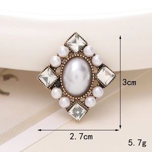 Macro shot of vintage pearl brooch with gold alloy base and crystals, 3cm x 2.7cm size