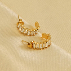 U-shaped gold plated earrings with rectangular zircons on champagne silk fabric