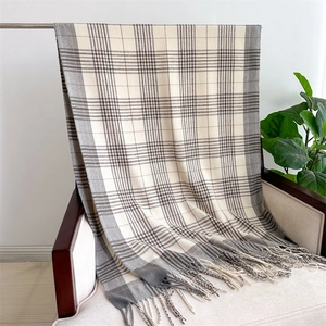 Detail showing soft cashmere-like fabric texture and grey checkered scarf tassels