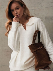 Detailed texture of white knit polo sweater set in soft fleece-like plush fabric