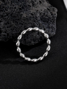 Macro shot of silver beaded stainless steel ring with polished reflective surface