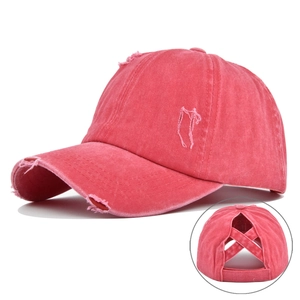 Detail view of pink distressed baseball cap showing the cross ponytail hole design