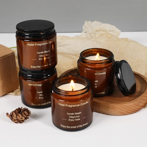 Aromatic amber glass jar candle 100g with gold stamping on a cozy wooden tray