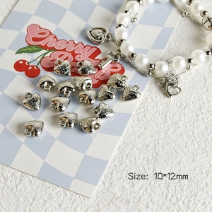 Detail of silver heart charm with Love engraving and rose pattern for DIY jewelry