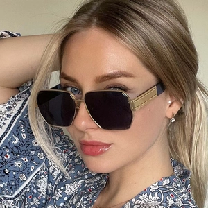 Chic oversized geometric sunglasses with gold metal frame and dark lenses on model