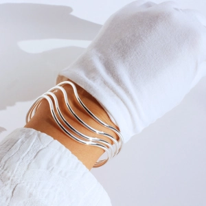 Detailed shot of multi-layer silver wave bangles with high-polished metallic finish