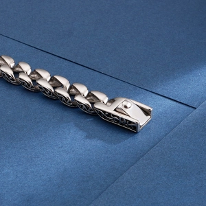 Detailed close-up of a silver vintage steel bracelet with intricate hollowed patterns