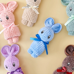 Flat lay of colorful coral fleece hand towels folded into cute bunny shapes with silk ribbons