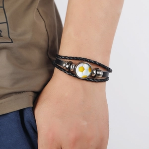 Close-up of a multi-layer black leather woven soccer bracelet worn on a wrist