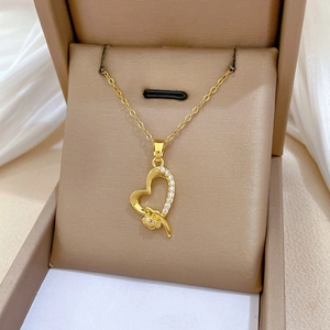Close-up of gold heart pendant with sparkling crystals on a luxurious jewelry gift box