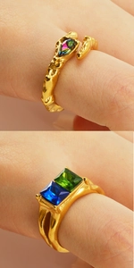 Detail of vintage gold open rings with iridescent pear stone and dual colored gems