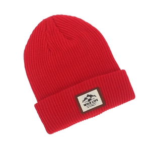 Detail of red knit beanie featuring a mountain bear patch and ribbed texture design