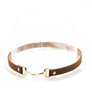 Detail of dark brown pebbled leather choker featuring a golden horsebit metal buckle