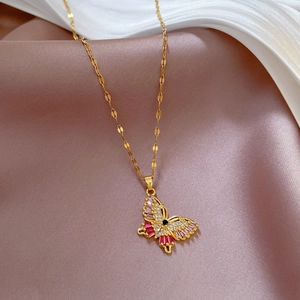 Detail of gold butterfly pendant with pink crystals and black stone on O-chain necklace