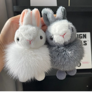 Detail of fluffy bunny plush keychains in white and grey with fox fur texture and long ears