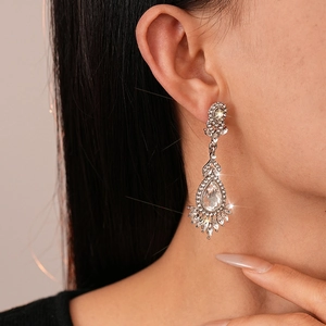 Sparkling crystal flower drop earrings in silver finish worn by a model in profile view