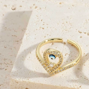 Close-up of gold adjustable evil eye ring with blue center and pavé zircon accents