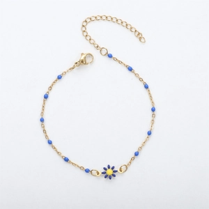 Golden chain bracelet featuring delicate blue beads and a blue daisy floral pendant