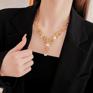 Primo piano della collana a goccia d'oro con cristalli indossata per uno stile raffinato