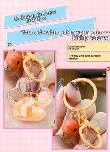 Detail of cute orange cat paw liquid quicksand keychain with bell and paint metal clip