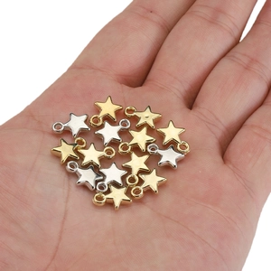 Gold and silver star charms for DIY jewelry held in hand to show the compact size