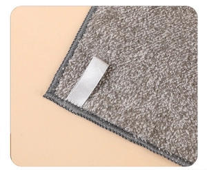 Close-up of thick gray microfiber cleaning cloth with soft texture and white label