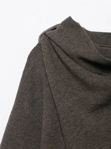 Detail of the asymmetrical pleated neckline on this dark brown knitted poncho sweater