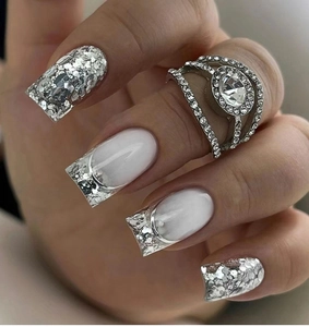 Detail of square silver glitter nails with white French tips and a zircon ring