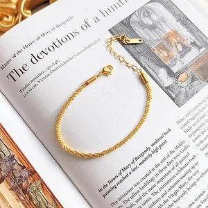 Minimalist 18K gold plated stainless steel star chain bracelet on a vintage book page