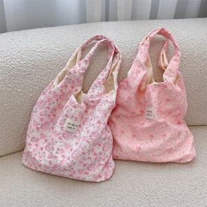 Detailed texture of quilted fabric on floral shoulder bag with cartoon rabbit pattern