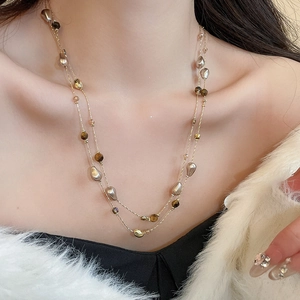 Close-up of 18k gold plated tiger eye and pearl double layer necklace on a model