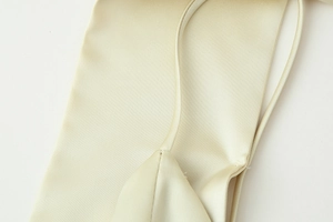 Detailed close-up of champagne satin fabric and delicate spaghetti straps on a dress